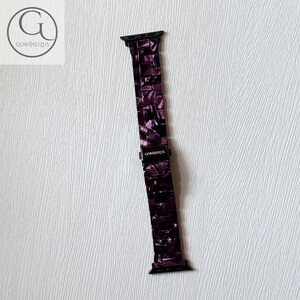 May include: A dark purple watch band featuring a glossy, marbled resin link design with black metal connectors at both ends. The central clasp is black and displays the white text GOBANDZUS, matching the logo visible in the top left corner.