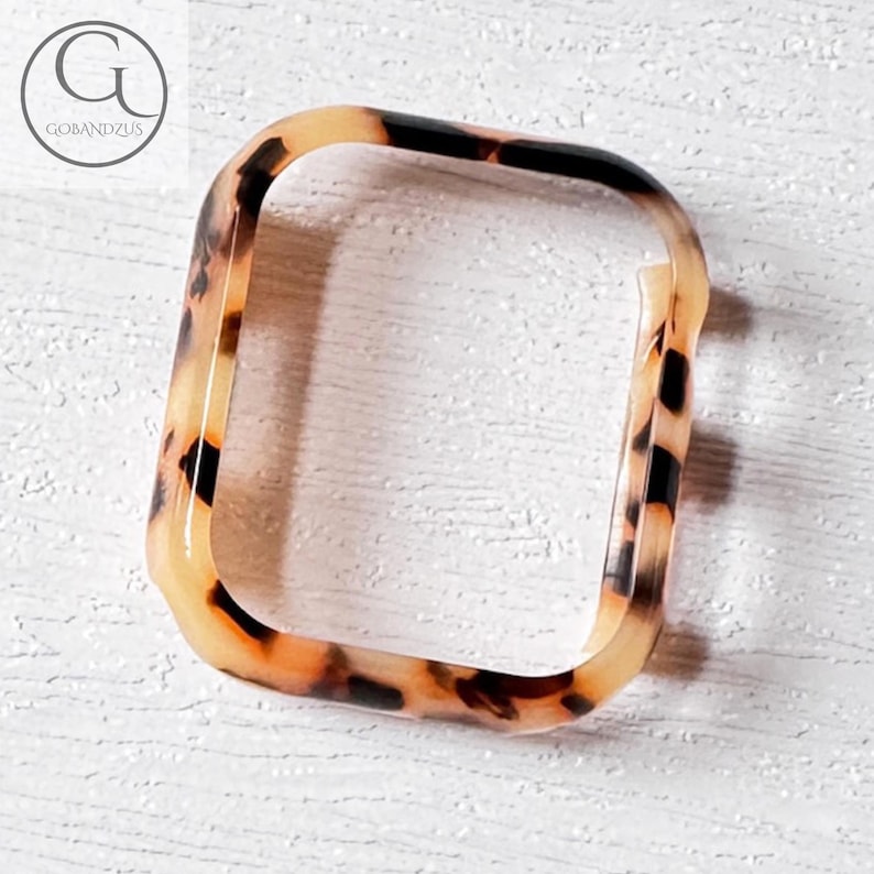 May include: A tortoiseshell patterned phone case with a clear back.