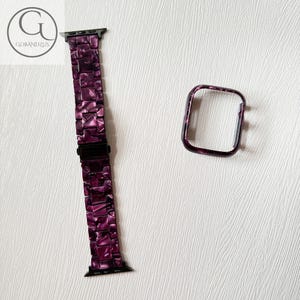 May include: A purple and black marbled resin watch band with a matching rectangular watch case cover. The band features a link-style design with a black metal clasp. The logo GOBANDZUS is visible in the top left corner of the image.