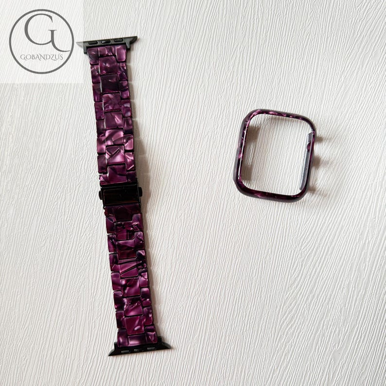 May include: A purple and black marbled resin watch band with a matching rectangular watch case cover. The band features a link-style design with a black metal clasp. The logo GOBANDZUS is visible in the top left corner of the image.