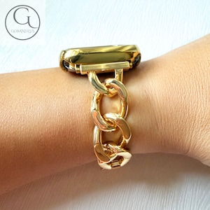 May include: A gold-colored watch band with a chain link design. The band is attached to a gold watch face. The watch band is worn on a wrist. The brand name "GOBANDZUS" is in the upper left corner.