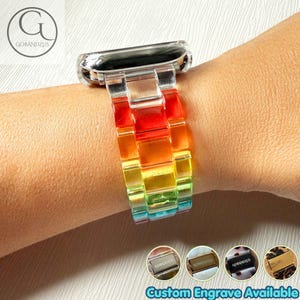 May include: A watch band featuring translucent, multi-colored resin links in a rainbow gradient of red, orange, yellow, green, and blue. The band connects to a metallic watch casing. Four small circular icons show metal clasps with text.