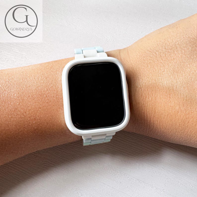 Op de afbeelding: Witte smartwatch met een wit en lichtblauw bandje. Het horloge heeft een zwart display en het bandje is gemaakt van siliconen.