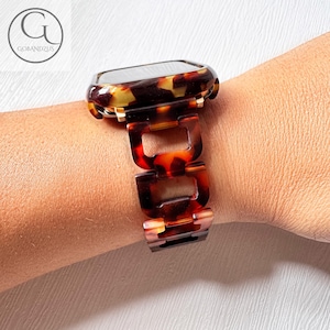 Könnte beinhalten: Ein braunes und goldenes Armband mit einem Schildpattmuster. Das Armband ist aus hartem Kunststoff und hat ein Gliederdesign.