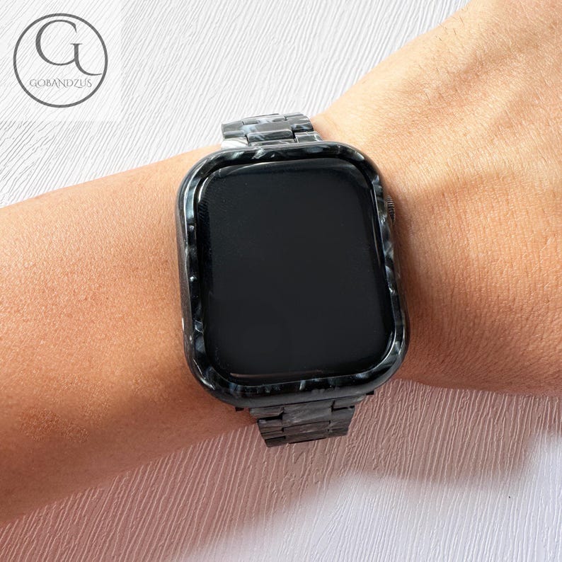 May include: A black and white patterned Apple Watch with a black metal band.