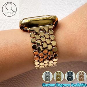 May include: A gold-toned watch strap featuring a repeating hexagonal link pattern. The strap is polished and metallic. Below the main image, four circular thumbnails display silver, gold, black, and rose gold versions of the same link design.