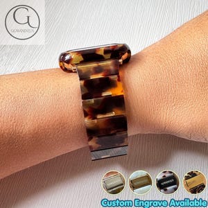Peut inclure: Un bracelet de montre au motif écaille de tortue marron et noir avec des maillons rectangulaires. Le bracelet est fixé par un fermoir métallique portant le texte gravé GOBANDZUS. Quatre vignettes circulaires en bas montrent diverses finitions.