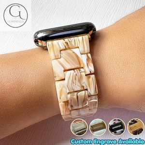 May include: A watch band featuring rectangular links with a cream and tan marbled resin pattern. The band connects to a dark metallic watch housing. Four small circular icons at the bottom display various metal clasp finishes with the text Custom Engrave Available.