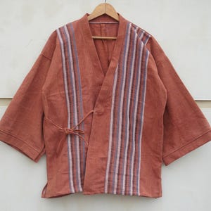 Puede incluir: Chaqueta estilo kimono de color &oacute;xido con cuello en V y mangas cortas. La parte delantera presenta rayas verticales en tonos blancos, morados y azules. Un cierre de lazo a juego est&aacute; en la cintura.