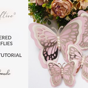Puede incluir: Tres mariposas de papel en capas de color rosa y plateado con detalles de perlas. Las mariposas est&aacute;n dispuestas en orden decreciente de tama&ntilde;o. La imagen incluye el texto "3D LAYERED BUTTERFLIES ASSEMBLY TUTORIAL".