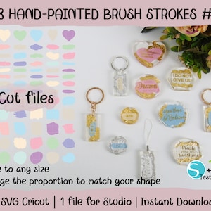 May include: 78 hand-painted brush stroke designs in various pastel colors. The image shows a variety of shapes, including hearts, circles, and rectangles. The brush strokes are arranged in a grid pattern. The image also includes a variety of keychains with different designs and sayings, such as "Dreams", "You Have to Believe", and "Create Your Own Sunshine".