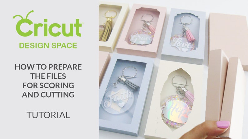 May include: A tutorial on how to prepare files for scoring and cutting using Cricut Design Space. The image shows several keychains with different words and colors, including "Faith", "Love", and "Hope", all in clear plastic boxes.