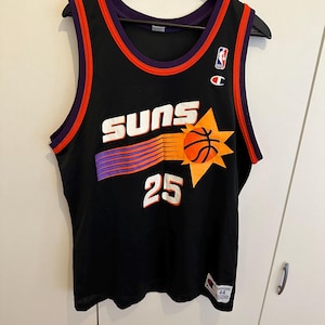 Op de afbeelding: Zwart basketbalshirt met paarse en oranje accenten. Het shirt toont het woord "SUNS" in het wit, een basketbalafbeelding en het nummer "25". Een Champion-logo is zichtbaar.