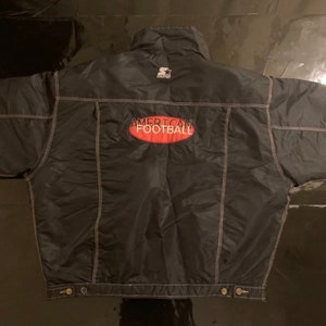 Könnte beinhalten: Schwarze Steppjacke mit weißem Steppdesign und einem roten "American Football"-Logo auf der Rückseite.