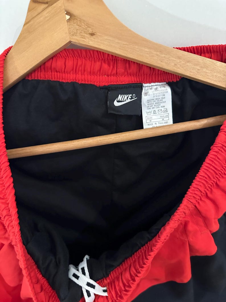 May include: Black and red Nike athletic shorts with a white drawstring. The tag reads "Nike" and "Made in Thailand".