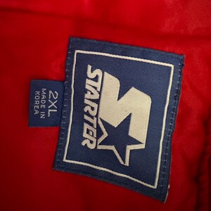 May include: A blue and white Starter brand label with a large white 'S' with a star inside. The label says 'Starter' and '2XL' and 'Made in Korea'.