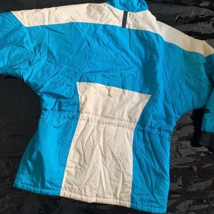 May include: A blue and white ski jacket with a zipper closure and a drawstring waist.