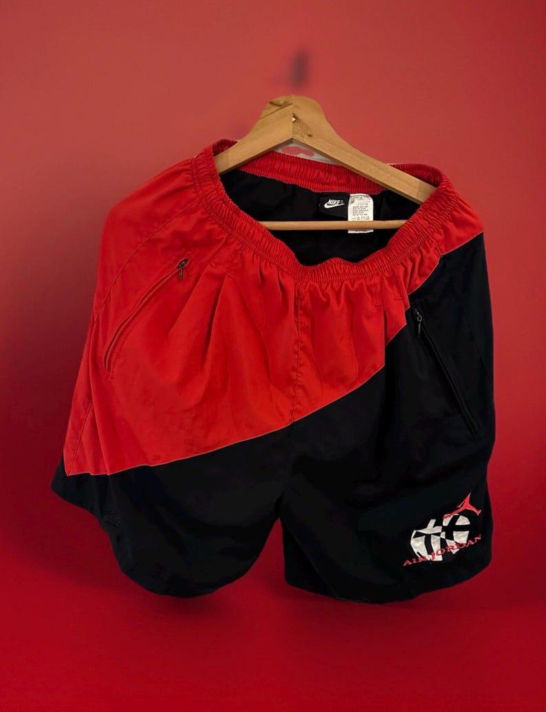 May include: Red and black athletic shorts with a white Nike logo and a white "Air Jordan" logo with a basketball and a fish graphic.