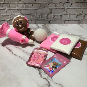 May include: A gingerbread person craft kit with pink and brown fondant, pink sprinkles, and a white styrofoam ball. The kit also includes two bags of white and brown modeling clay.