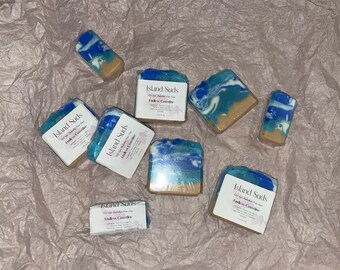 May include: Six bars of handmade soap with a blue and white swirl design. The soap is labelled "Island Suds Endless Coastline".