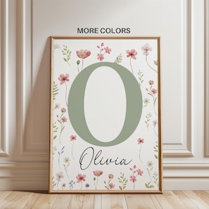 Puede incluir: Un estampado floral enmarcado con la letra "O" en verde salvia, rodeada de flores de acuarela rosas y rojas. El nombre "Olivia" está escrito en cursiva debajo. Las palabras "MORE COLORS" están en la parte superior.
