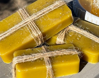May include: Three rectangular bars of beeswax wrapped in twine. The beeswax is a light yellow color.