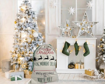 May include: A beige Christmas gift bag with a drawstring closure. The bag features the text "Merry Christmas" in red script, along with a silhouette of Santa's sleigh and reindeer. The text "Special Midnight Delivery" and "Packed by Santa's Elves at The North Pole" are also printed on the bag.