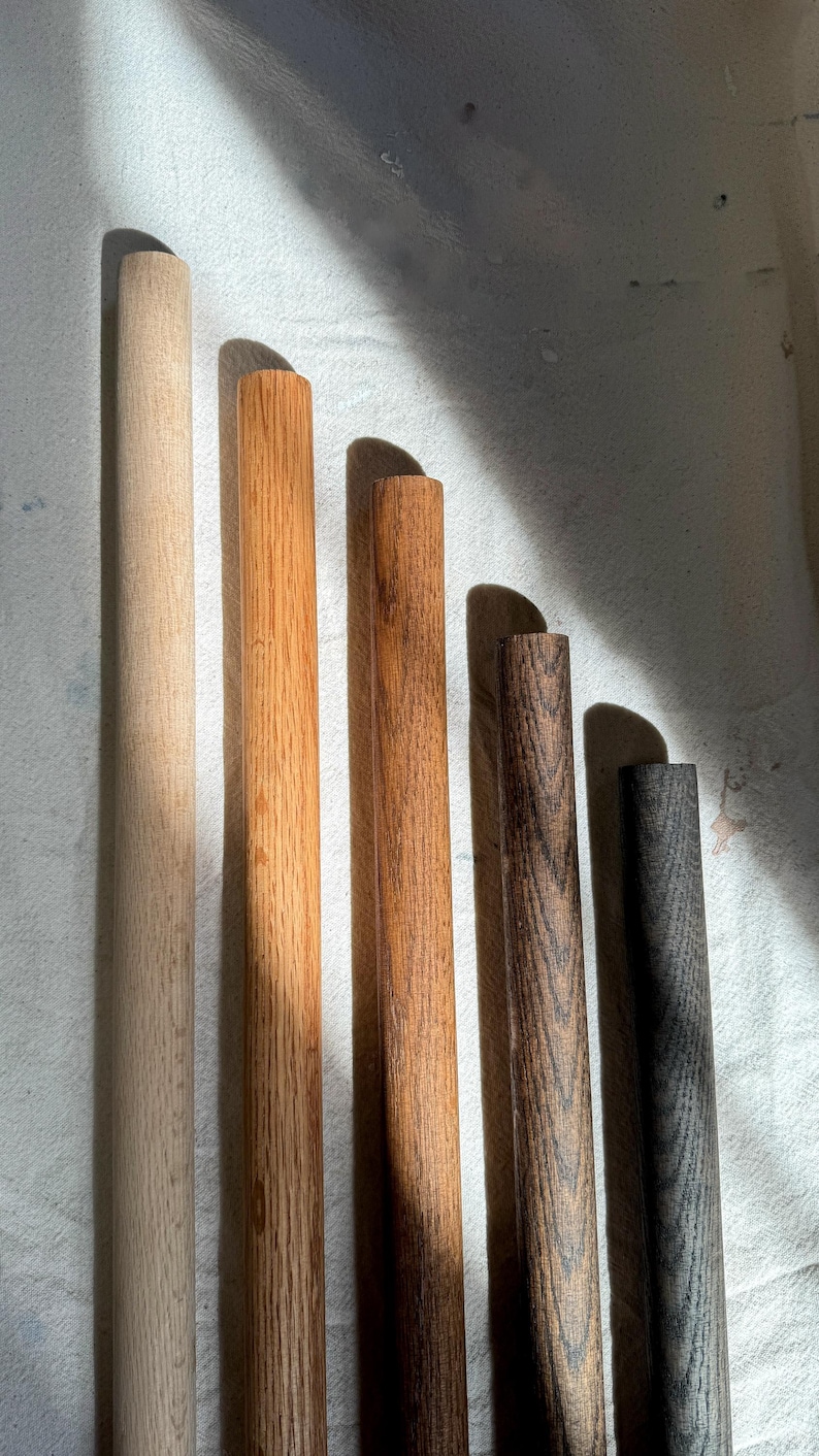 The image displays five wood finishes: Black (dark and bold), Dark Brown (rich with deep grain), Brown (warm and classic), Natural (light with a smooth finish), and Unfinished (raw, untreated wood surface).