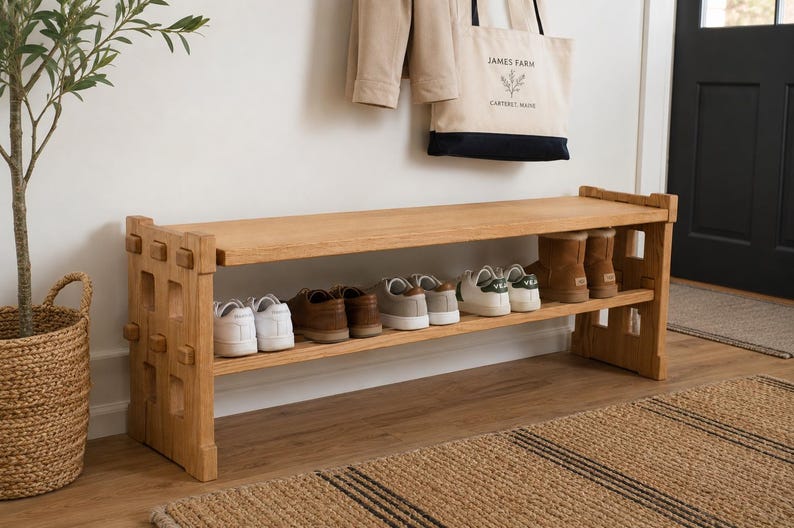 May include: A light brown wooden shoe bench with two horizontal shelves featuring a grid-like side panel design. The bench holds several pairs of trainers and boots on its shelves, providing organised storage for footwear in a hallway setting.