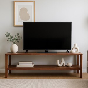 May include: A modern living room setup featuring a dark wood TV stand with a black screen television. Decorative vases and a potted plant add to the room's aesthetic. A framed abstract art piece hangs on the wall.