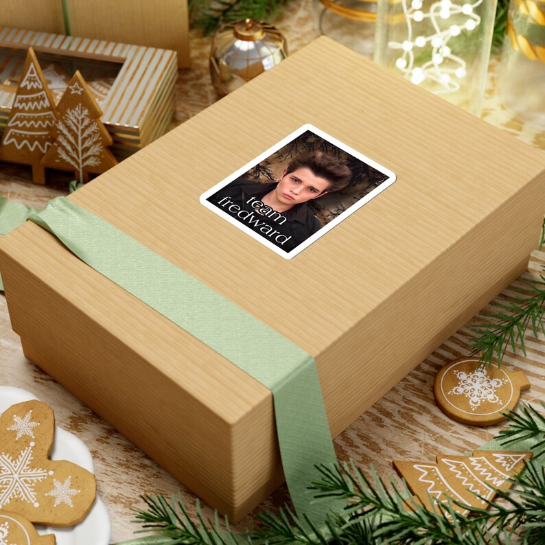 May include: A brown gift box with a green ribbon and a sticker that says "Team Edward" with a picture of a young man with dark hair.