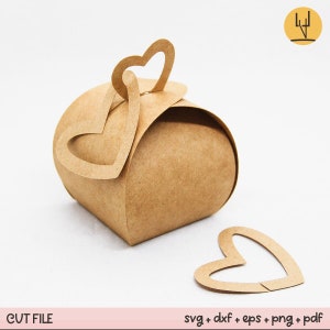 May include: A brown paper favour box with a heart-shaped cut-out on the top. The box is open and there is a separate heart-shaped cut-out on the table next to the box.