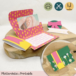 May include: A printable Christmas card template with a pink and yellow design featuring a string of lights and a photo slot. The card is folded and has a space for a message. The template is also available as a digital cutting file.