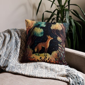 May include: A throw pillow with a colorful illustration of a deer standing in a forest at night. The deer is brown and white with a starry sky in the background.