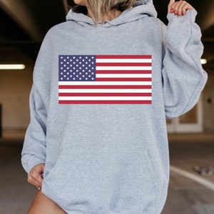 May include: A gray hooded sweatshirt with a large American flag printed on the front.