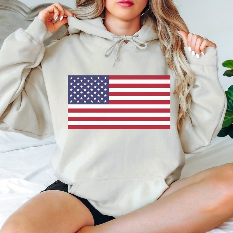 May include: A light gray hoodie with a red, white, and blue American flag printed on the front.