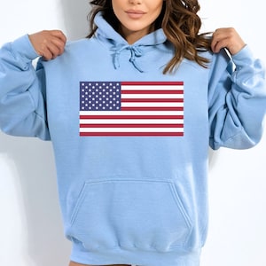 May include: A light blue hoodie with a printed American flag on the front.
