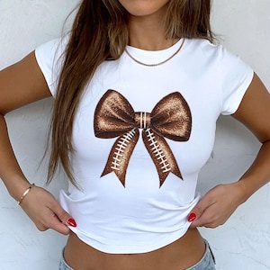 Football Faux Glitter Bow Print Women&#39;s Baby Tee - Sports Fan Gift, Sparkly Graphic Shirt, Team Spirit Apparel, Cute Game Day Top, Tailgate