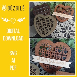 Puede incluir: Dos adornos de madera en forma de corazón con un diseño de corazones más pequeños cortado con láser. Los adornos tienen un acabado marrón y marrón claro. El adorno más grande tiene una pancarta con el texto "#BeMyValentine".