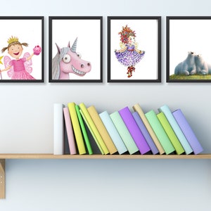 Op de afbeelding: Vier ingelijste illustraties op een witte muur boven een houten plank met een stapel kleurrijke boeken. De illustraties omvatten een fee met een toverstaf en een cupcake, een eenhoorn, een meisje met rood haar en een paarse jurk, en twee ijsberen.