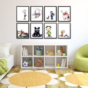 Op de afbeelding: Een witte muur met acht ingelijste zwart-wit illustraties van cartoonfiguren. De illustraties zijn gerangschikt in twee rijen van vier. De muur bevindt zich in een kamer met een witte boekenkast, een groene zitzak en een wit bed met groene beddengoed.