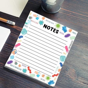 May include: A white notepad with a colorful border of various infectious agents, including viruses, bacteria, fungi, and protozoa. The notepad has lined pages and the word "NOTES" in bold black letters at the top.