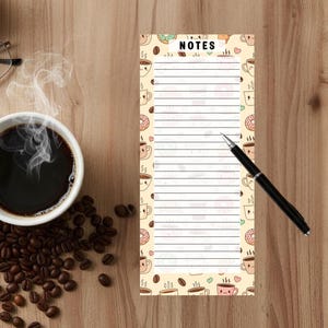 May include: A notepad with the word "NOTES" at the top, surrounded by coffee cups and donuts. A black pen rests on the notepad. A cup of coffee and coffee beans are on a wooden surface.