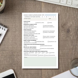 May include: A white notepad with the text "HOME CARE SUPERVISOR CONSULTATION NOTES" is on a wooden surface. The notepad includes checkboxes for various care settings, purposes of consultation, and care tasks. A pen and keyboard are visible in the background.