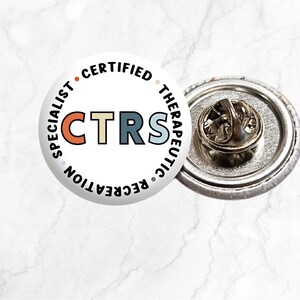 May include: A white button badge with the text "Certified Therapeutic Recreation Specialist" surrounding the acronym "CTRS" in colourful letters.