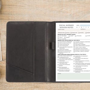 May include: A black leatherette Social Worker Session Notes binder with a notepad insert. The notepad has a detailed form with checkboxes for various session types, focus areas, and completed tasks. The text "SOCIAL WORKER SESSION NOTES" is visible.