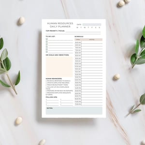 May include: A white Human Resources daily planner with a schedule and to-do list. The planner includes sections for HR goals, admin reminders, and follow-ups. The text is in a clean, easy-to-read font, with a neutral colour palette.