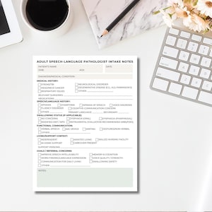 May include: A printed Adult Speech-Language Pathologist Intake Notes form. The form includes sections for patient information, medical history, speech/language history, swallowing status, functional communication, and goals. A pencil and keyboard are in the background.