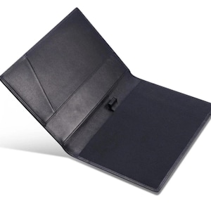May include: Open black leather portfolio with a dark blue interior. The portfolio has a flap closure and several interior pockets. The cover is smooth and the interior has a textured appearance. The portfolio is open, displaying the inside.