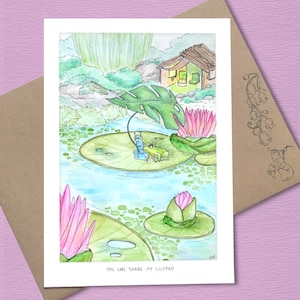 以下が含まれることがあります： 水彩画のグリーティングカード。スイレン、ピンクの蓮の花、小さな家がある池の風景が描かれています。カエルとイモムシがスイレンの葉の上にいます。「YOU CAN SHARE MY LILYPAD」というテキストが下にあります。